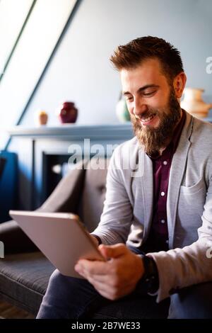 Young business man working, relaxing on the sofa with a tablet Stock Photo