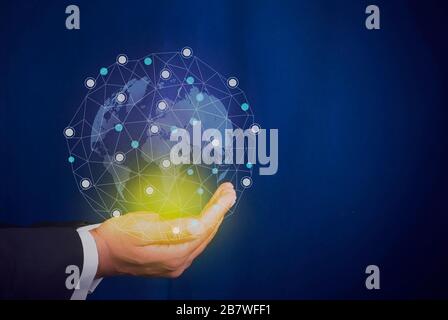 Businessman holding the world map with connecting dots in hands Stock Photo