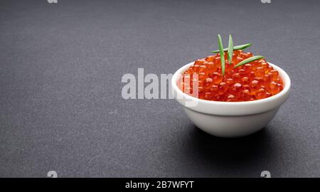 Red caviar on black stone background with copy space close-up Stock Photo