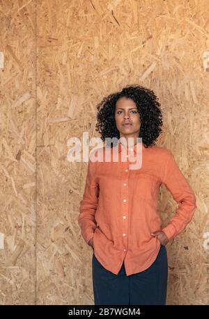 Aspirational young woman standing by a wall in her workshop Stock Photo