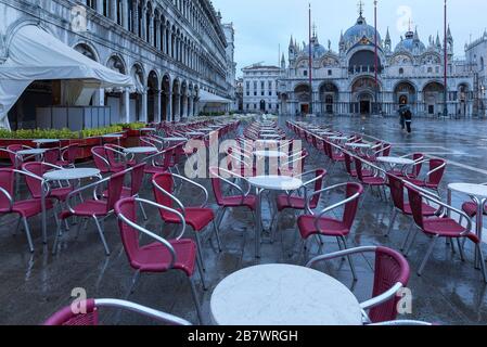 Empty St Mark's Square with arcades of the old procuration, 16th century and St Mark's Cathedral in the early morning in rainy weather, Venice Stock Photo