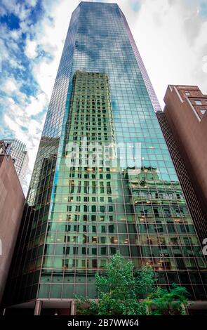New York, NYC / July 17 2014: Buildings reflected on glass facade of another building in midtown Manhattan. Stock Photo