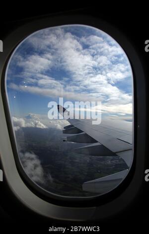 Aeroplane Boeing 747-400 (744) in flight View of Wing showing Flap Track Fairings through the Window Stock Photo