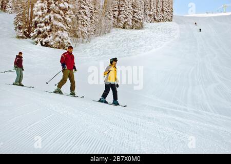 Happy family skiing on slopes. Stock Photo
