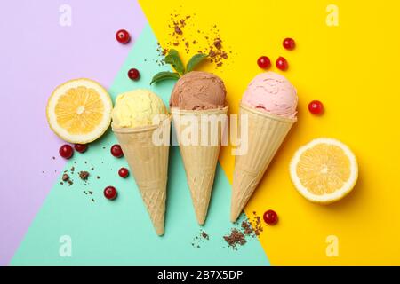 Ice cream in cones, lemon and cranberry on multicolor background. Sweet food Stock Photo