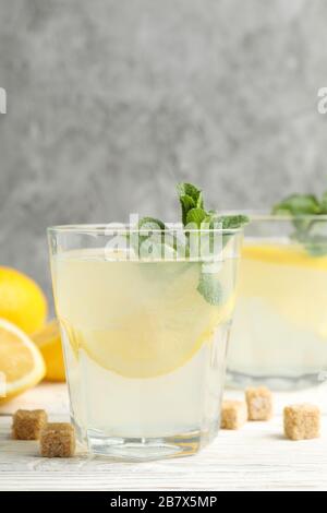 Lemonade, lemons and sugar cubes on wooden background, space for text Stock Photo