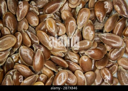 brown flax seeds under the magnifying glass Stock Photo