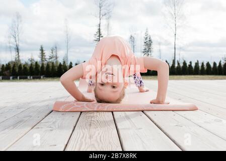 young girl doing gymnastics and yoga in her back yard at home Stock Photo