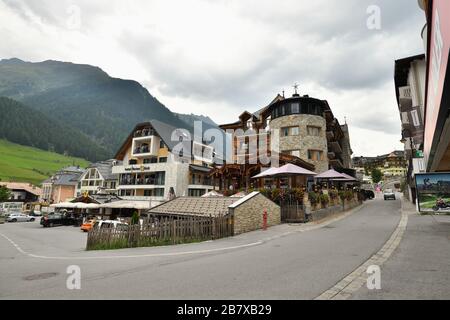 ISCHGL, TYROL, AUSTRIA - AUGUST 28, 2019: Wide angle panorama of Ischgl town center. Architecture with hotels and apres ski alpine lodges, street view Stock Photo