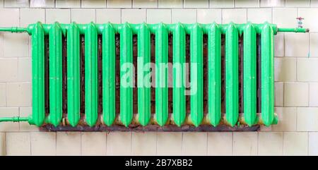 Old cast-iron heating radiator in grunge style. Stock Photo