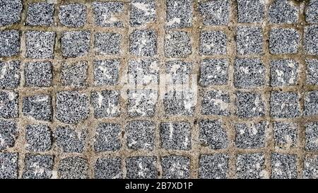 surface paved with black road tiles. top view. Granite paving stones on a sidewalk or pavement textured paving background. Close up top view Stock Photo