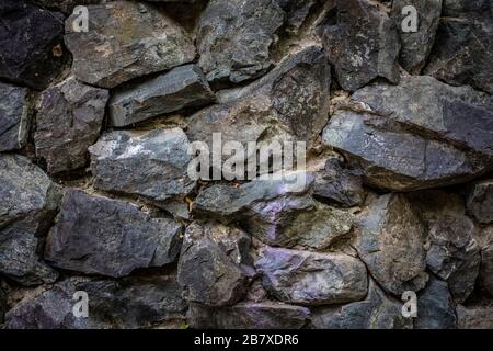 Part of the stone wall, for background and texture. Rough cut natural stone Stock Photo