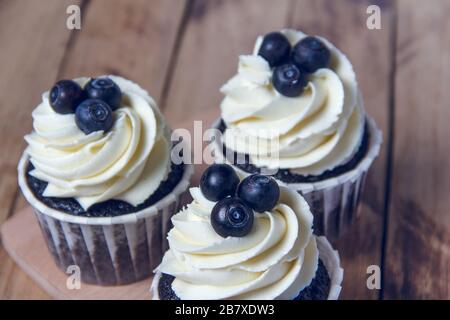 Chocolate cupcakes with white cream and blueberry. Stock Photo