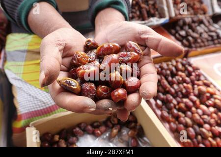 man hand holding date fruit for sale  Stock Photo