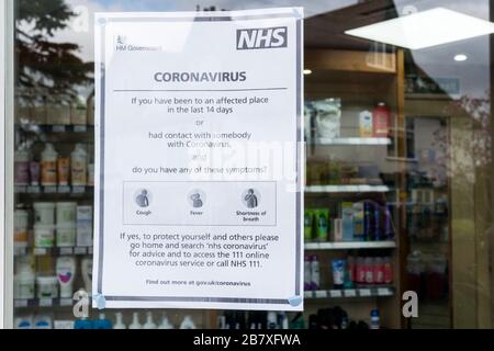 18 March 2020. Bromley, South London, UK.  Sign on a chemist's shop gives instructions to people who may have been in contact with the Covid 19 Coronavirus.  Credit UrbanImages-news/Alamy Stock Photo