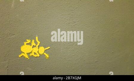 yellow painted ant on a gray wall. Ant climbing a wall. Colorful ants backgrounds. Local artists decorate the walls of the streets Stock Photo