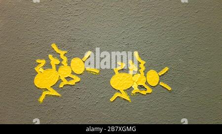 yellow painted ant on a gray wall. Ant climbing a wall. Colorful ants backgrounds. Local artists decorate the walls of the streets Stock Photo
