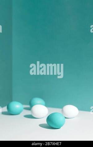 Five multi-colored eggs with a hard shadow. They're in the corner of the box. Concept. Stock Photo