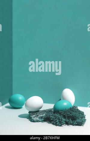 Four multi-colored eggs and natural materials moss and wood. Easter concept. Stock Photo