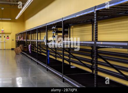 No toilet paper or paper towels are on the shelves of a supermarket because shoppers are hoarding due to the coronavirus pandemic. Stock Photo