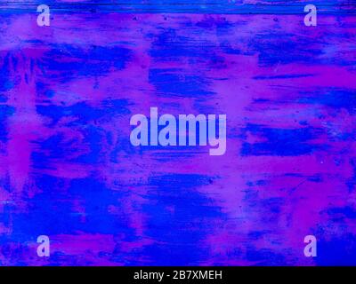 An old rusty iron wall painted with large strokes of deep blue and purple Stock Photo