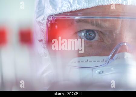 Virologist healthcare professional analyzing blood test sample in lab tubes, close up of medical worker working, selective focus Stock Photo