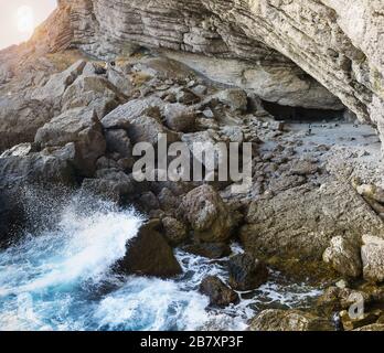 At sunset, the waves beat on the rocks at the beach Stock Photo - Alamy