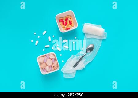 Pills and drug abuse concept top view flat lay with medication served as food on blue background Stock Photo