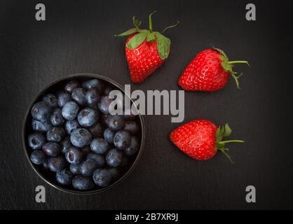 A studio photograph of a bowl of blueberries and strawberries Stock Photo