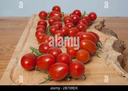 Tomatoes on a vine in a kitchen setting Stock Photo