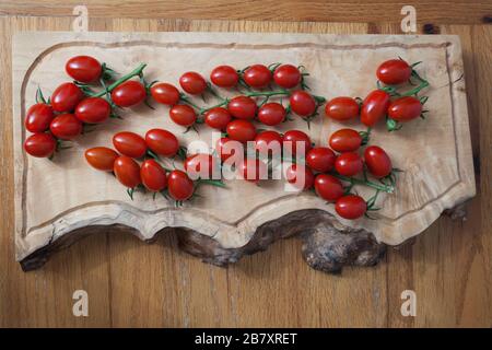 Tomatoes on a vine in a kitchen setting Stock Photo
