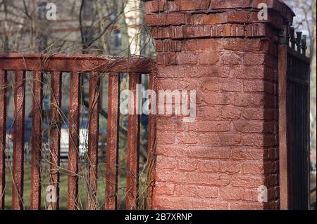 Freshly painted in red old fence, outdoor cropped shot Stock Photo