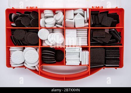 orange colored plastic box with round and square felt pads Stock Photo