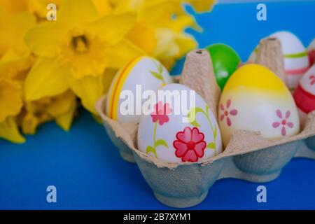 Happy Easter. Easter holiday decorations on trendy colored classic blue background. Creative spring composition with Easter elements - flowers and egg Stock Photo