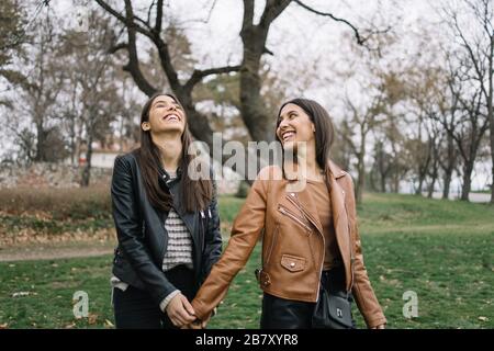 Woman holding her sister's hand and walking through sea garden Stock Photo
