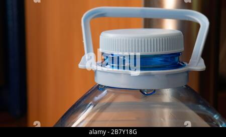 Five liter bottle - close up. Plastic container with water. Blue plastic bottle stopper. Stock Photo