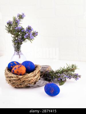 Speckled easter eggs with white blossom flowers and green leaves ...