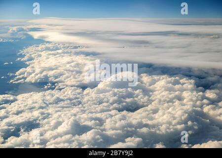 Aerial view of white puffy clouds viewed from an airplane. Stock Photo