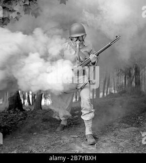 Sergeant George Camblair learning how to use a gas mask in a practice smokescreen, Fort Belvoir, Virginia, USA, Jack Delano for U.S. Office of War Information, September 1942 Stock Photo