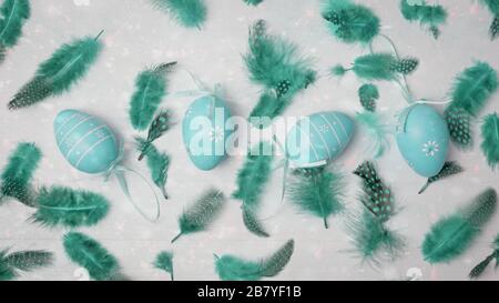 Easter concept. Pastel colored eggs and feathers on light background with space for text. Top view, flat lay. Stock Photo