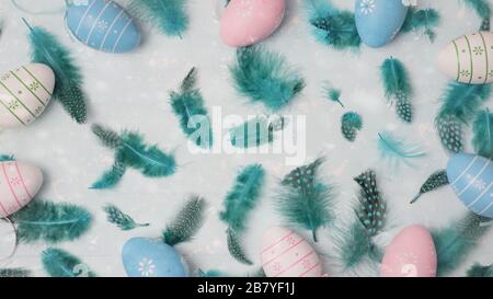 Easter concept. Pastel colored eggs and feathers on light background with space for text. Top view, flat lay. Stock Photo