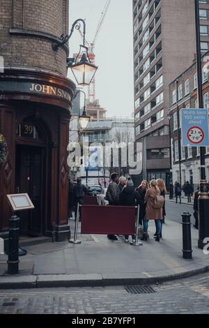 London, UK - March 06, 2020: People standing and drinking outside John Snow pub in Soho, an area of London famous for LGBTQ+ bars, restaurants and clu Stock Photo