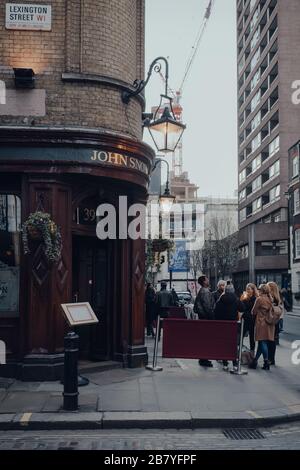 London, UK - March 06, 2020: People standing and drinking outside John Snow pub in Soho, an area of London famous for LGBTQ+ bars, restaurants and clu Stock Photo