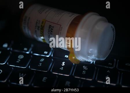 Pill bottle on computer keyboard Stock Photo