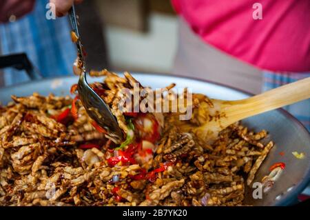 Deep fried tempe in sweet soy sauce (kecap manis) being cooked. Tempe Kering. Stock Photo