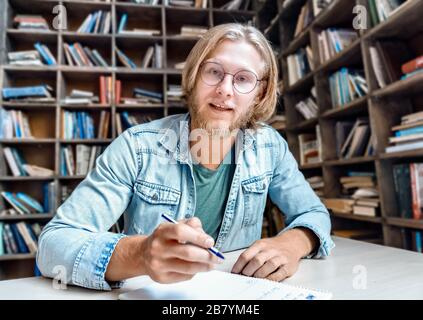 Male online tutor teacher looking at camera teaching student online. Stock Photo