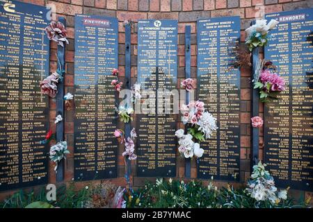 The brick wall, flowers and names on the Australian Truck Drivers Memorial Wall. In Tarcutta, New South Wales, Australia. Stock Photo