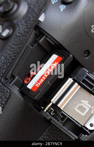 The memory card in camera slot. The memory card inserted to card hole in open door of the digital camera. Stock Photo