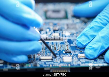 Asian Technician repairing micro circuit main board computer electronic technology : hardware, mobile phone, upgrade, cleaning concept. Stock Photo