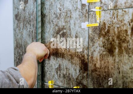 Spreading wet mortar before applying tiles on bathroom floor tile. Stock Photo